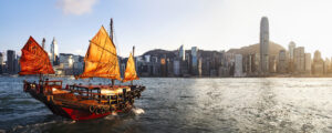 Hong Kong’s Victoria Harbor with traditional red sail junk boat Business Class from London to Hong Kong